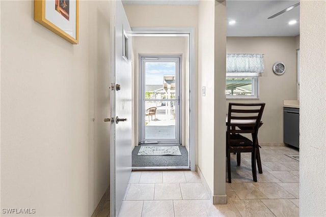 doorway to outside with light tile patterned flooring