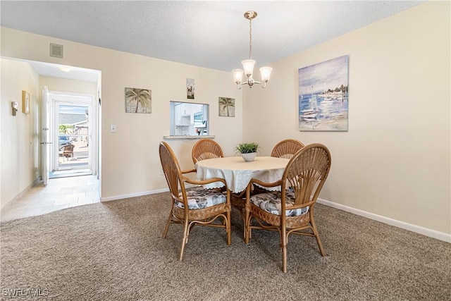 dining room featuring carpet and an inviting chandelier