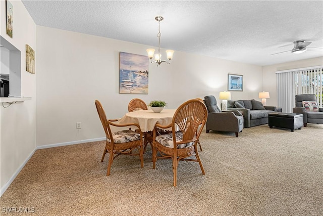 carpeted dining room with a textured ceiling and ceiling fan with notable chandelier