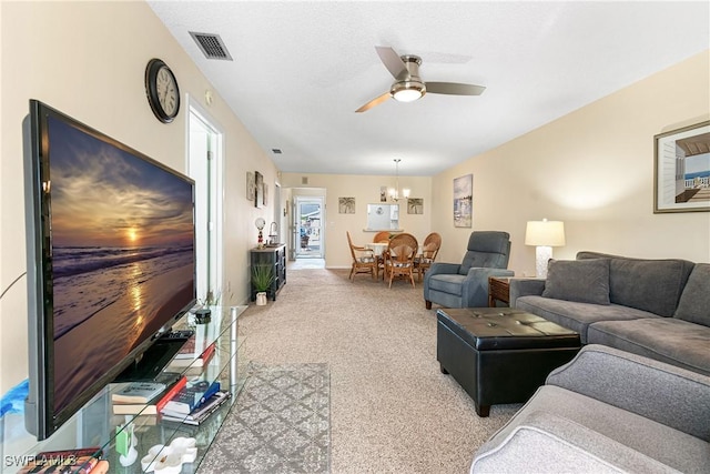 living room with carpet flooring and ceiling fan with notable chandelier