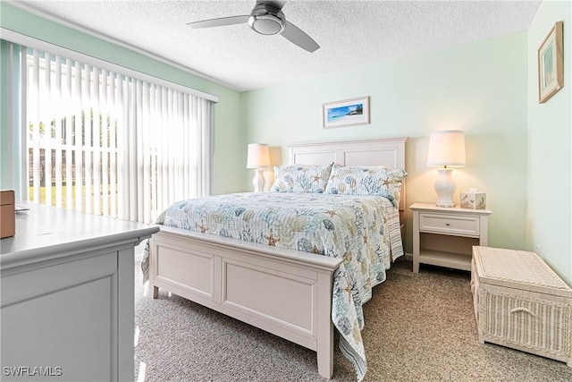 carpeted bedroom with ceiling fan and a textured ceiling