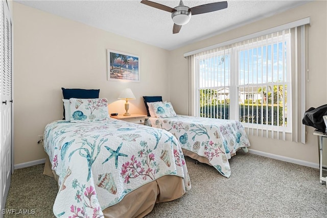 carpeted bedroom featuring ceiling fan, a closet, and a textured ceiling