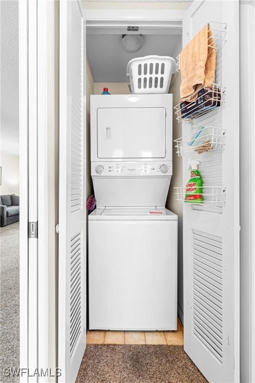 laundry area featuring light carpet and stacked washer and dryer