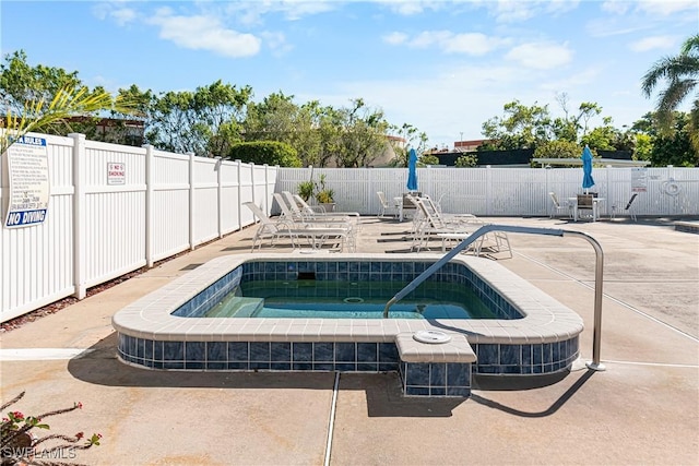 view of swimming pool with a hot tub