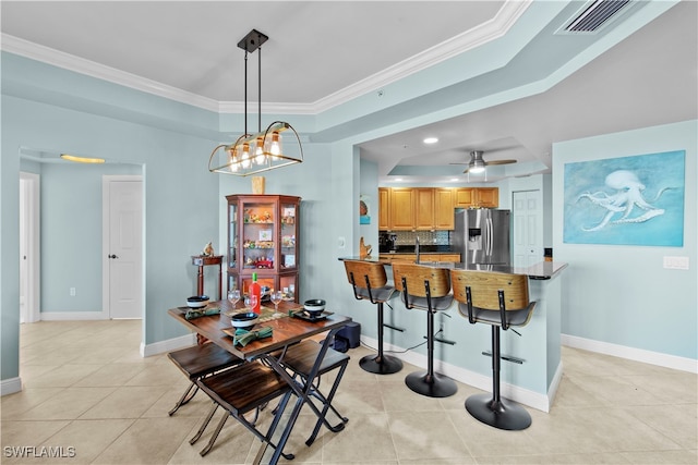 kitchen with crown molding, stainless steel refrigerator with ice dispenser, hanging light fixtures, ceiling fan, and kitchen peninsula