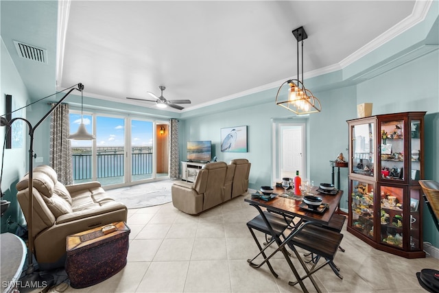 living room featuring ceiling fan, a raised ceiling, ornamental molding, and light tile patterned floors