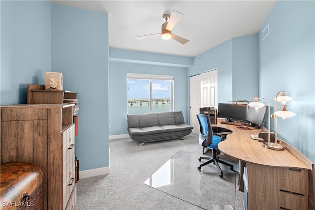 carpeted office space featuring ceiling fan