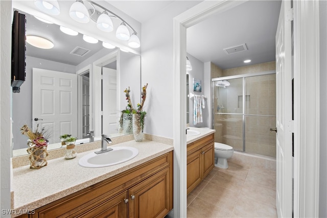 bathroom with tile patterned floors, vanity, walk in shower, and toilet