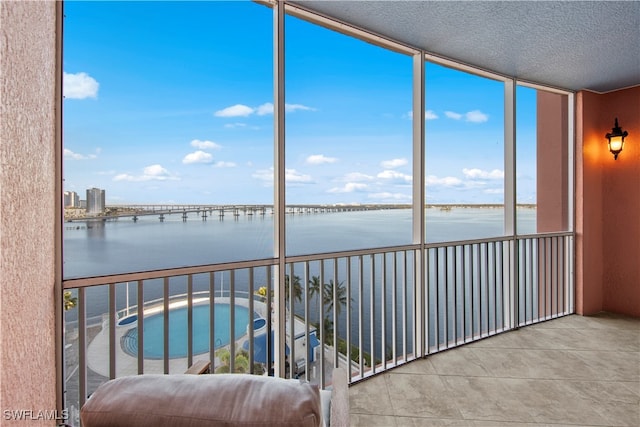 unfurnished sunroom featuring a water view