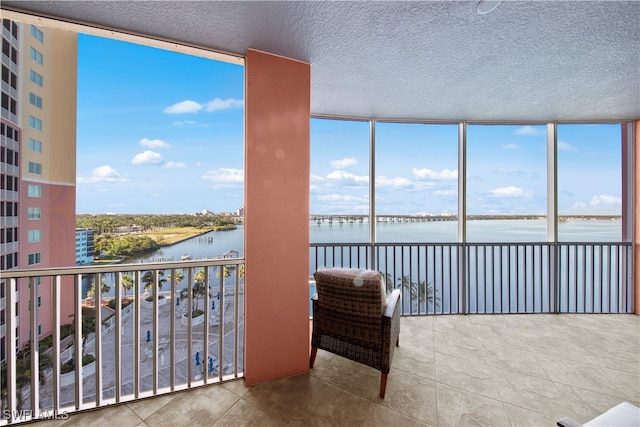 sunroom featuring a water view