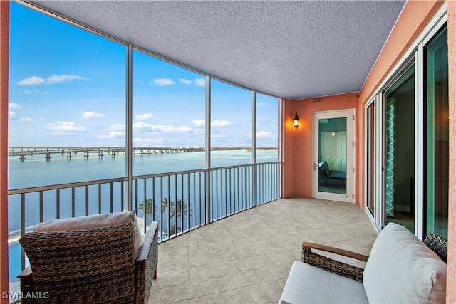 sunroom / solarium featuring a water view