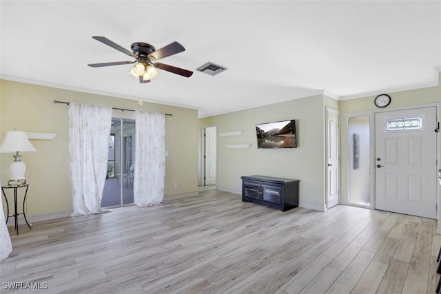 foyer entrance featuring visible vents, plenty of natural light, crown molding, and wood finished floors