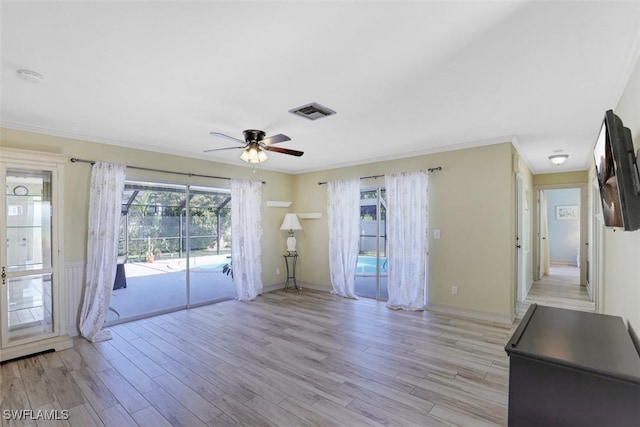 unfurnished living room featuring visible vents, crown molding, and light wood-type flooring