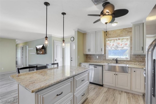 kitchen featuring sink, dishwasher, a center island, decorative light fixtures, and light wood-type flooring