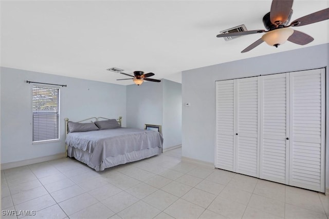 tiled bedroom featuring ceiling fan and a closet