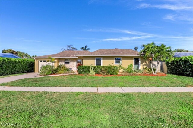 ranch-style house featuring a garage and a front yard