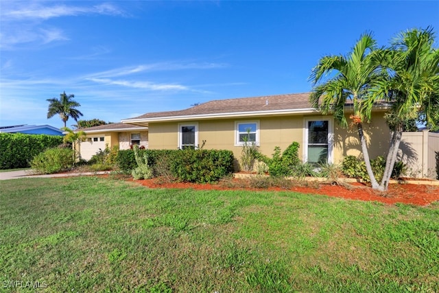 ranch-style house with a front yard, a garage, and stucco siding