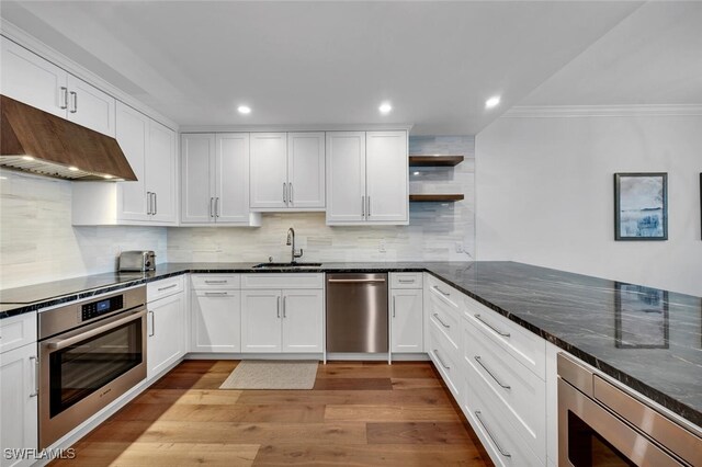 kitchen featuring stainless steel appliances, premium range hood, sink, and white cabinetry