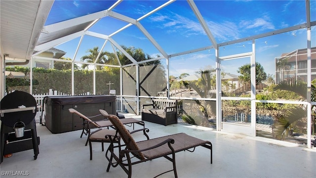 view of patio featuring glass enclosure, a grill, and a hot tub