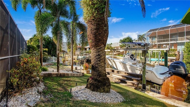 view of yard featuring glass enclosure and a boat dock