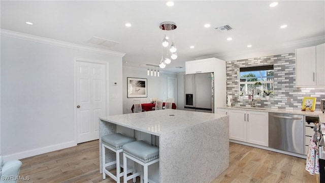 kitchen featuring white cabinets, a center island, and appliances with stainless steel finishes