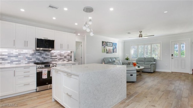 kitchen featuring white cabinetry, a center island, stainless steel appliances, and light hardwood / wood-style floors