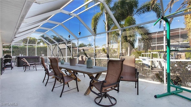 view of patio / terrace with a hot tub and a lanai