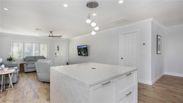 kitchen featuring ceiling fan, crown molding, decorative light fixtures, light hardwood / wood-style floors, and white cabinetry