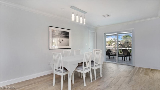 dining room with light hardwood / wood-style flooring and ornamental molding