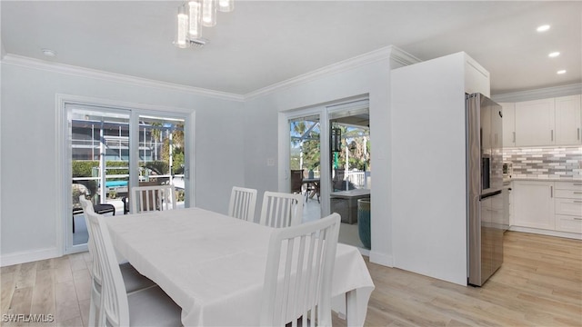 dining room with light hardwood / wood-style flooring and ornamental molding