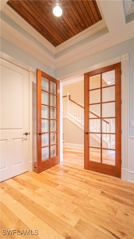 corridor featuring hardwood / wood-style floors, wood ceiling, crown molding, and french doors