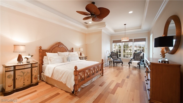 bedroom with a tray ceiling, ceiling fan, light hardwood / wood-style floors, and ornamental molding