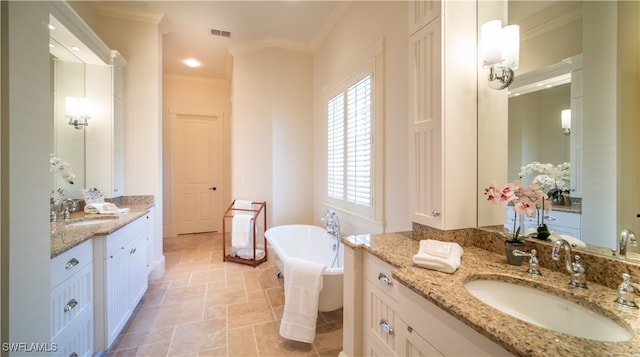 bathroom with a bathing tub, vanity, and ornamental molding