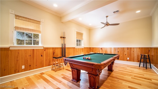 recreation room featuring ceiling fan, wooden walls, wood-type flooring, and ornamental molding