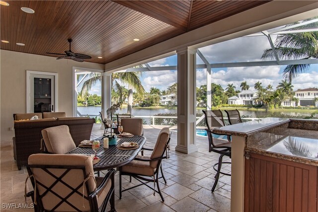 exterior space featuring a wealth of natural light, ceiling fan, a water view, and wood ceiling