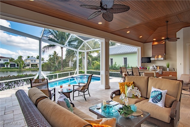 view of patio featuring outdoor lounge area, ceiling fan, a water view, and a lanai