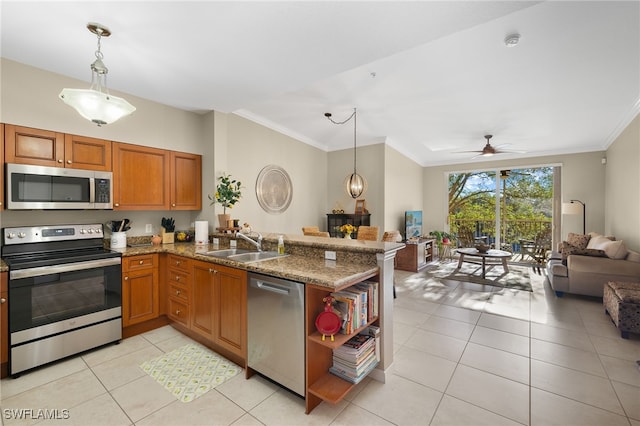 kitchen featuring decorative light fixtures, sink, kitchen peninsula, and stainless steel appliances