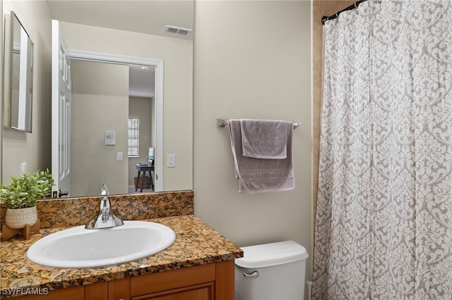 bathroom featuring vanity and toilet