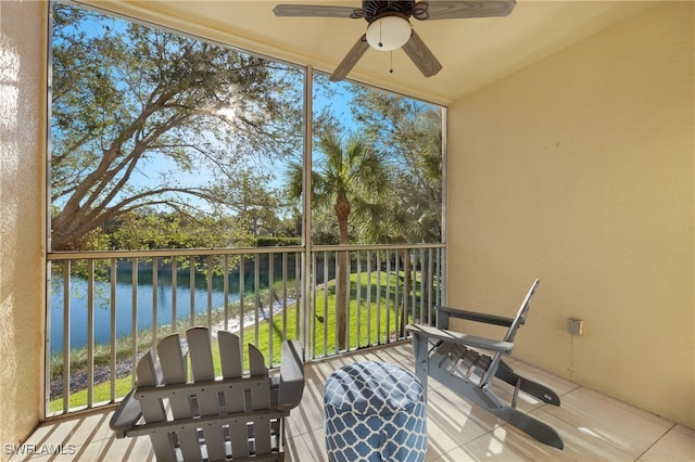 balcony with ceiling fan and a water view