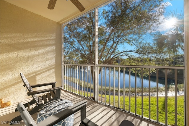 balcony featuring a water view and ceiling fan