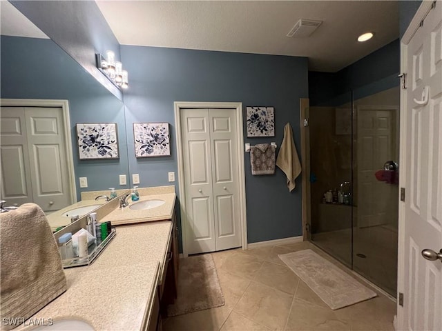 bathroom with tile patterned flooring, vanity, and walk in shower