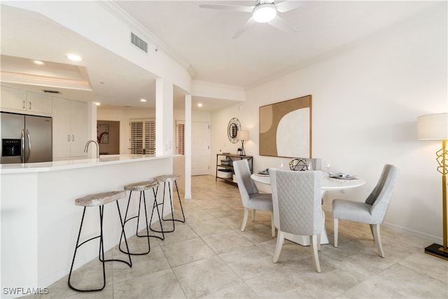 dining space with ceiling fan, light tile patterned flooring, and ornamental molding