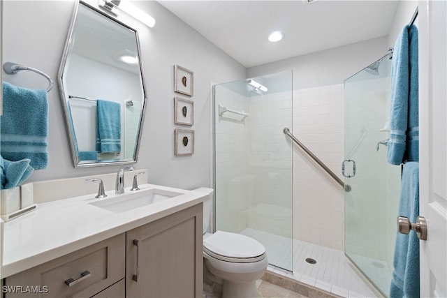 bathroom featuring tile patterned flooring, vanity, toilet, and a shower with shower door