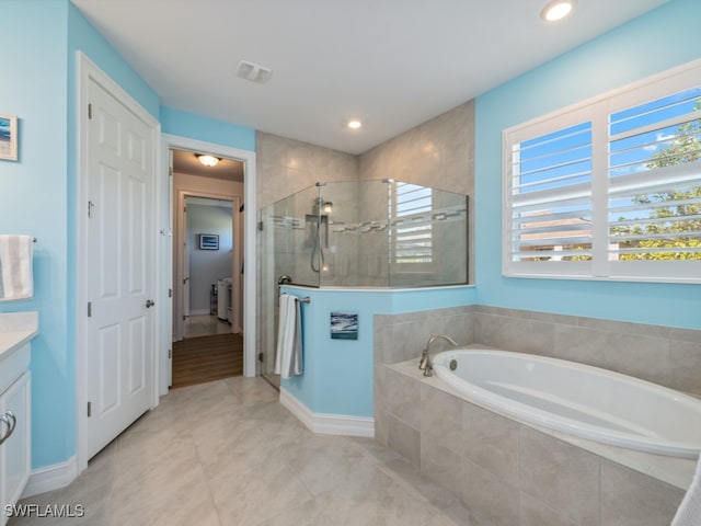 bathroom with vanity and shower with separate bathtub