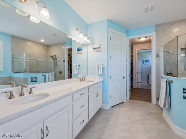 bathroom with tile patterned flooring, vanity, and walk in shower