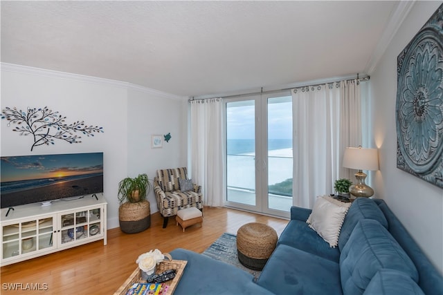 living room with a water view, ornamental molding, and hardwood / wood-style flooring