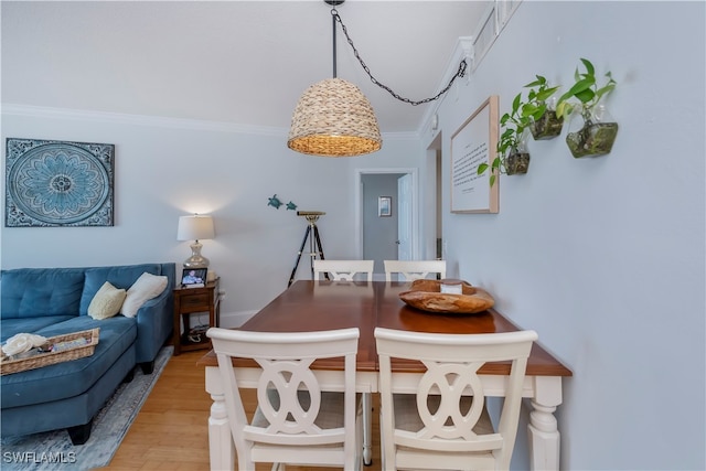 dining room with light hardwood / wood-style flooring and ornamental molding