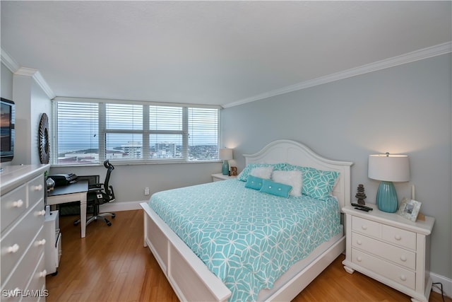 bedroom with crown molding and light hardwood / wood-style flooring