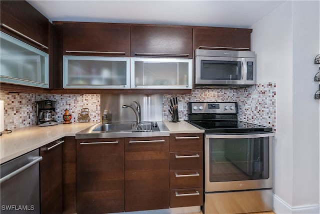 kitchen featuring backsplash, stainless steel appliances, dark brown cabinetry, and sink