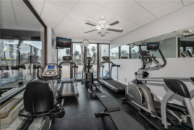 gym with a paneled ceiling and ceiling fan